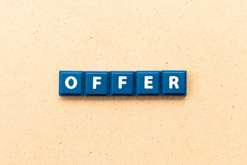 Tile letter in word offer on wood background