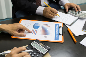 Business man Writing expense information in home office.team work concept