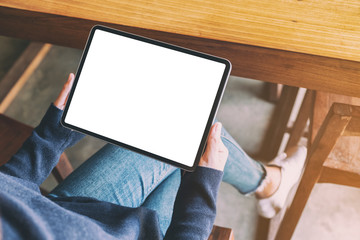 mockup image of a woman holding black tablet pc with blank white screen while sitting in cafe
