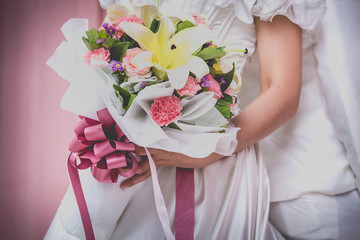 Couple holding a bouquet of flowers with a happy wedding day