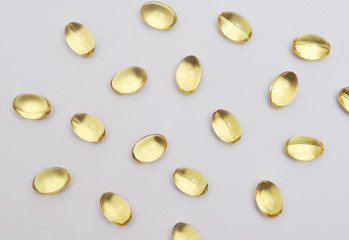 Fish fat in capsule on light background.