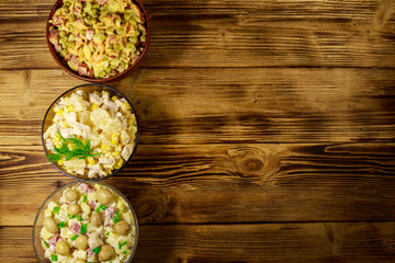 Set of festive mayonnaise salads on wooden table. Top view, copy space