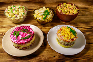 Fototapeta na wymiar Set of festive mayonnaise salads on wooden table
