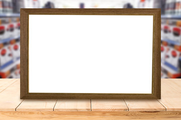 empty blank board on wooden table or wooden mock up over blurred supermarket background.