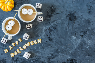 Halloween pumpkin cupcakes with 2 cups of coffee and marshmallow eyes