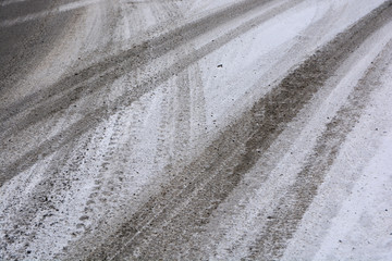 The tread marks of car tires on winter road.