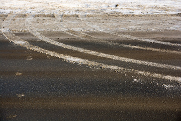 The tread marks of car tires on winter road.