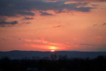 Sunrise peaking over horizon over mountain