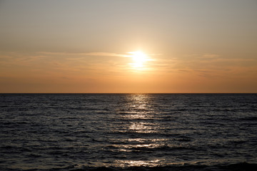Dark sea surface with waves and sun reflection