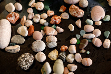 Collection of various colored sea pebbles on black background