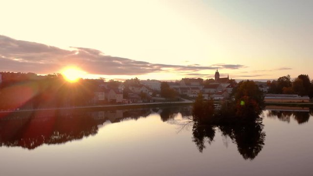 Aerial footage on the pond in the middle of the city, historic town in Poland, recreational path around the lake in the city, ancient buildings of the city, beautiful sunset in Warmia and Mazury