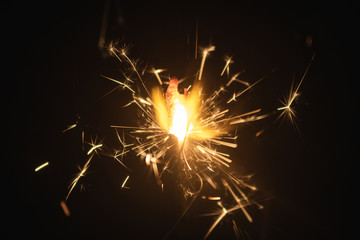 burning sparkler on black background