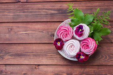 Colorful zephyr on wooden background.Set of homemade white and pink zephyr or marshmallow on wooden background. Marshmallow, Meringue, Zephyr, pansy.Tasty meringues.Copy space