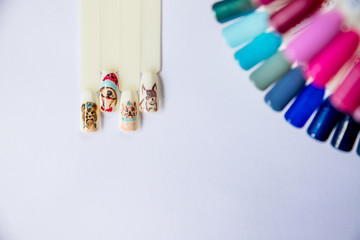 Christmas Nail art manicure. Winter Holiday style bright Manicure with gems Christmas tree and snowflakes. Bottle of Nail Polish. Manicure Design. Christmas decorations.Copy space