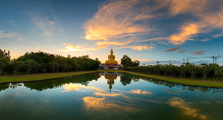 Beautiful Big Golden Buddha statue sunset sky in Thailand temple,khueang nai District, Ubon Ratchathani province, Thailand.Amazing Buddha image with sunny sky clouds.