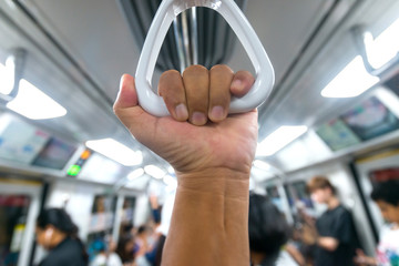 Passenger  hand holding onto a handle of a train on blur background. © noon@photo
