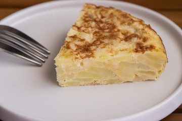 Close up of Tortilla slices, Spanish omelette  with fork.  Traditional Spanish tapa background.. .