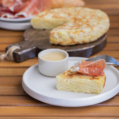 Tortilla Spanish omelette served with traditional jamon and bread. Spanish cuisine background.