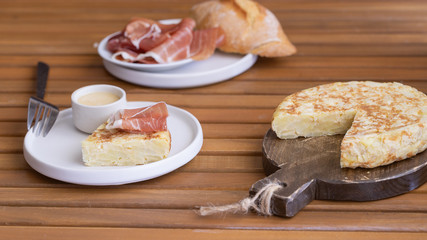 Tortilla Spanish omelette served with traditional jamon and bread. Spanish cuisine background.