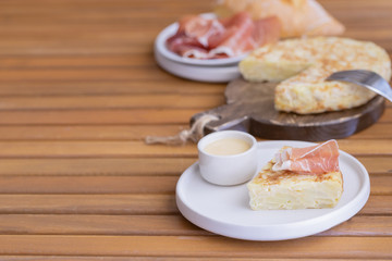 Tortilla Spanish omelette served with traditional jamon and bread. Spanish cuisine background.