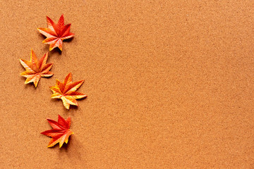 close up top view group of maple leaves on vintage brown cork wood table background texture for autumn season collection design concept