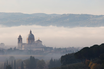 Obraz premium Surreal view of Santa Maria degli Angeli papal church (Assisi) almost completely hidden by fog