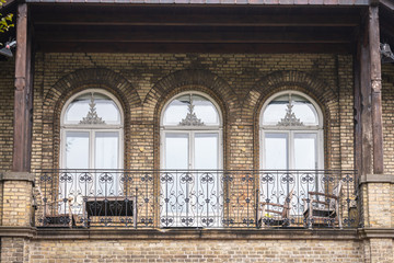 Fototapeta premium An ornate older house with a nice bright balcony with chairs and tables