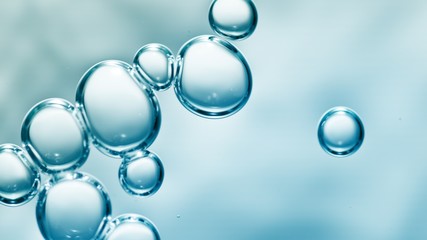 transparent gas bubbles on water surface. Worms-eye low angle with crystal bubbles in purified water on blue background. cosmetic background with copy space