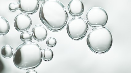 transparent gas bubbles on water surface. Worms-eye low angle with crystal bubbles in purified water on white background. cosmetic backdrop with copy space