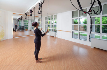 una donna controlla le corde prima di eseguire un esercizio di pilates in palestra