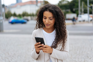 Young woman reading a phone message with a smile