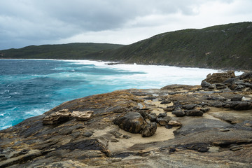 Fototapeta na wymiar The Natural Gap, Albany, Western Australia. Dramatic and moody landscape with large rough waves breaking on the rocks. 