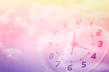 double exposure of cloudy sky and clock at six o'clock , time passing concept