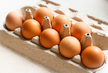 The brown eggs in egg box.
