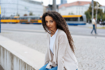 Young woman sitting on the parapet of a bridge