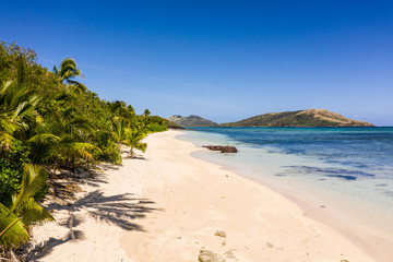 Stunning white sand beach by the blue lagoon in the Yasawa island in Fiji in the south Pacific.