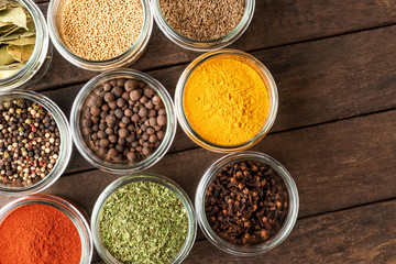 Colourful spices in bowls on wooden table. Big collection of spices. Top view