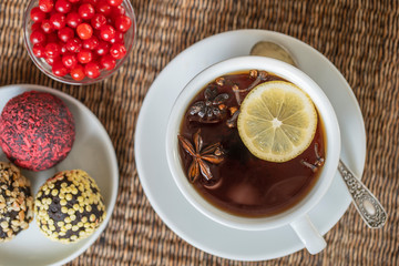Spice tea, consisting of cinnamon, black pepper, cardamom, star anise, lemon, cloves and hot apple juice. Close up, top view