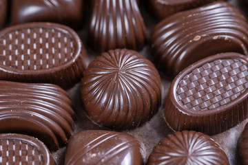 Brown chocolate candy background. Assortment of chocolate candies sweets
