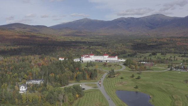 Aerial view of White Mountains in New Hampshire with white and red hotel building in foreground