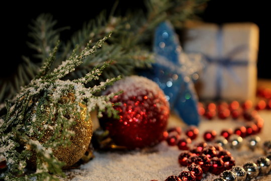 beautiful Christmas photo with twigs of spruce, Christmas toys on the background of falling snow