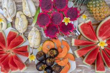 Tropical fruits assortment, closeup, top view. Many colorful ripe fruits background. Durian,...