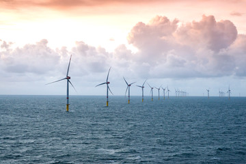Sunset over offshore wind farm - green power generation