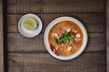 Top view Thai food Tom Yum soup with shrimps isolated on rustic wooden table