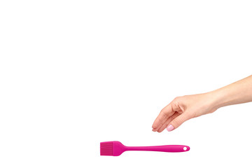 Hand with pink culinary brush, kitchen utensil.