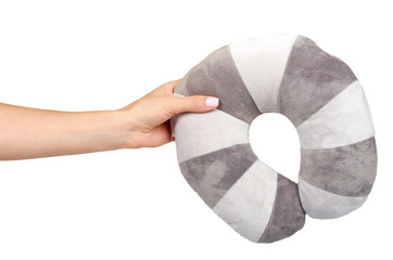 Hand with travel pillow, gray colored, soft and puffy.