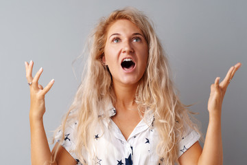 Portrait of angry irritated young woman over gray background