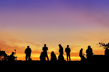 Fototapeta na wymiar Silhouette of group people travel happy holiday on cliff view their sunrise.