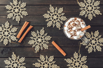 hot cocoa with marshmallows and cinnamon, surrounded by Christmas decorations on a wooden table, Christmas atmosphere concept