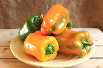 A plate with bell peppers stands on a wooden table.